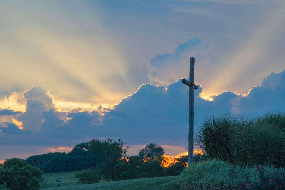 cross on hill at sunset